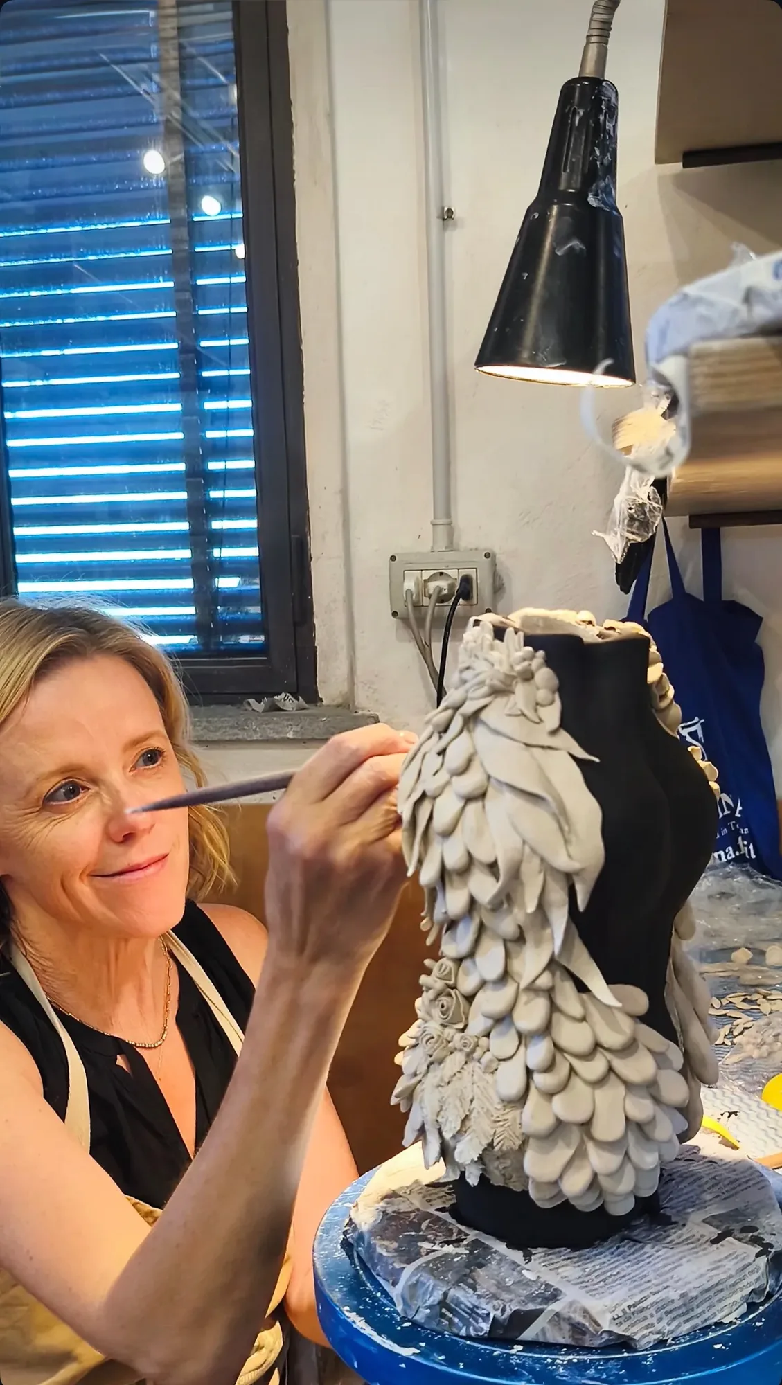 Krysta Mae shaping a tall ruffled sculpture in her Orinda studio