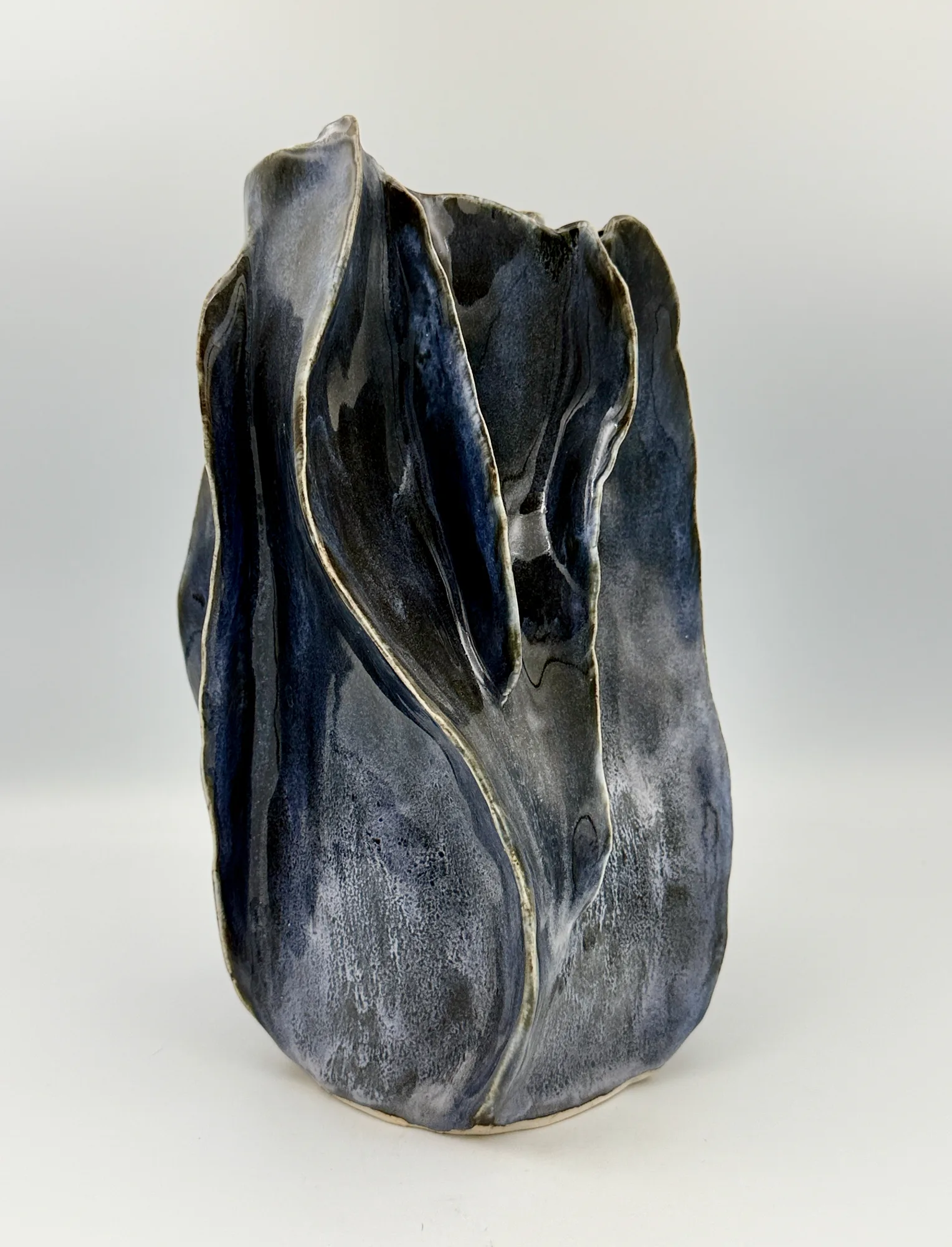 A tall folded vessel in blue and grey glaze